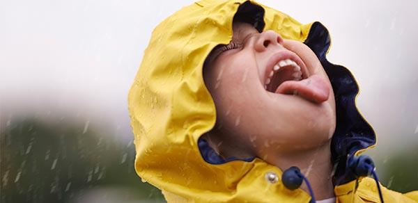 Child catching raindrops in their mouth